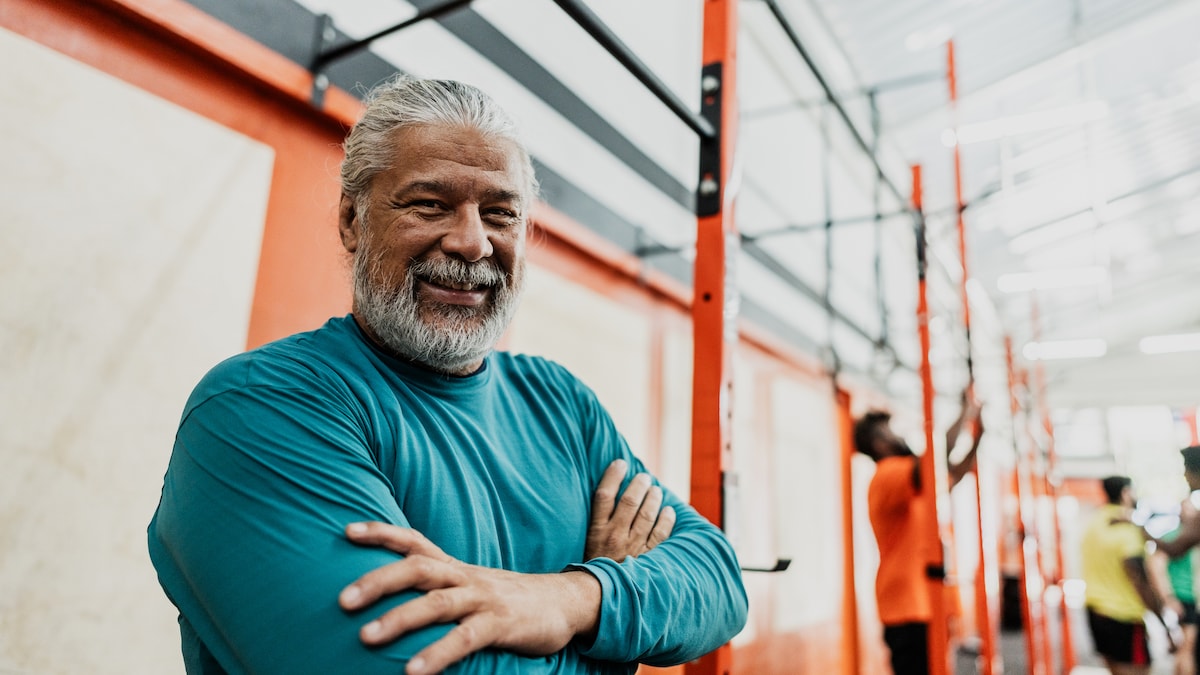 Älterer Mann steht im Fitnessstudio