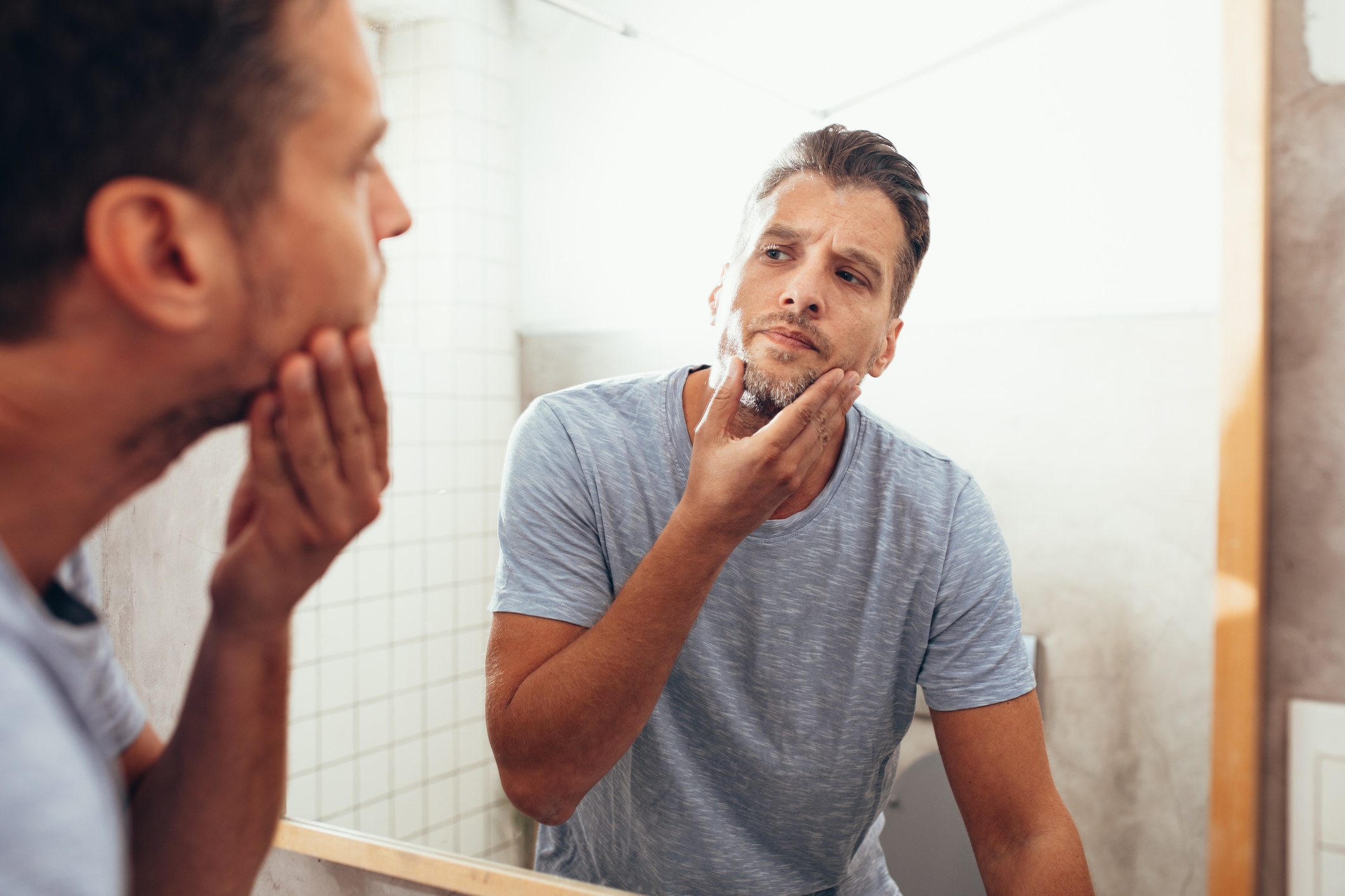 White Man Checking Himself Out in a Bathroom Mirror