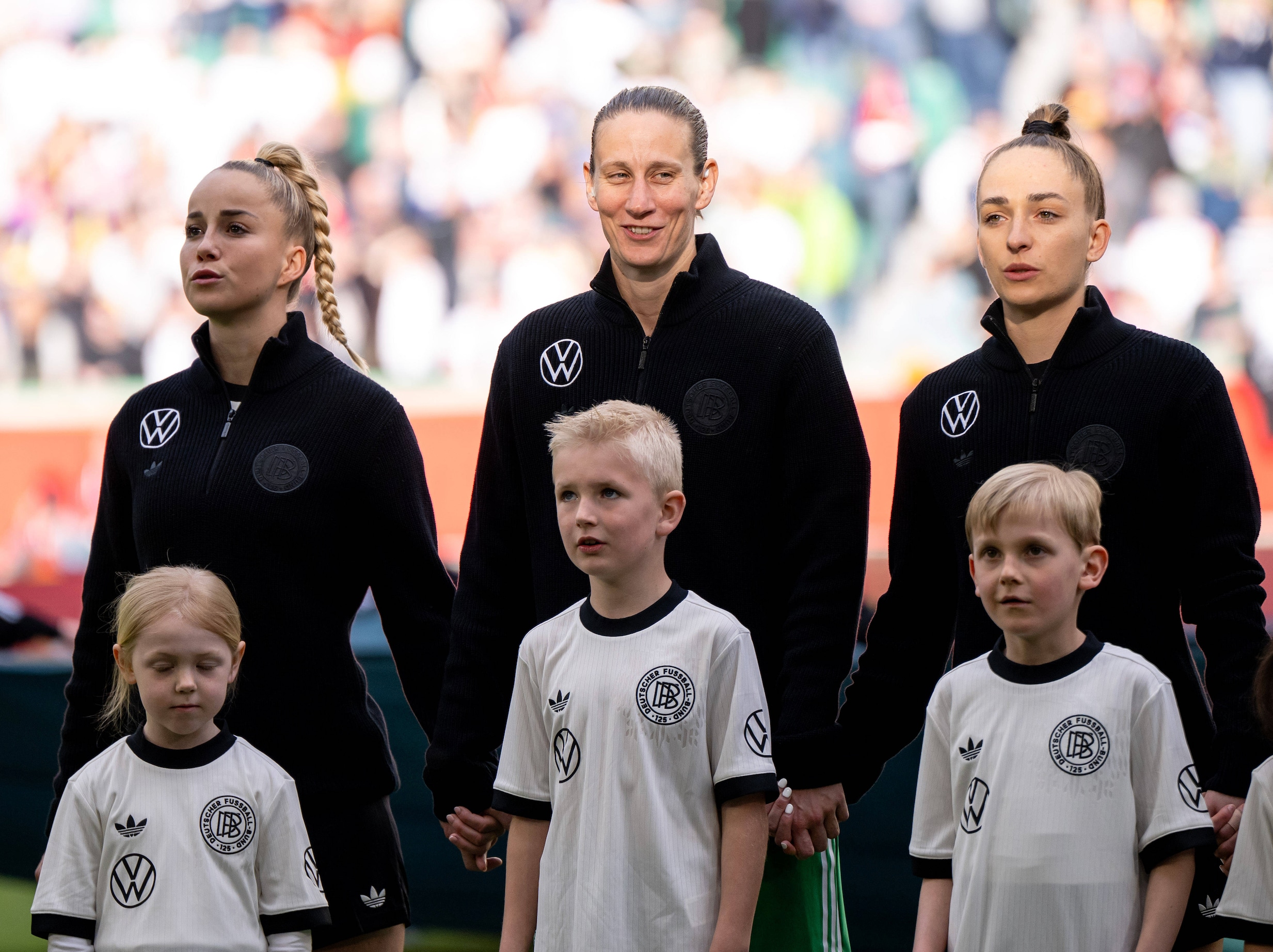 Terwijl andere spelers er serieus uitzien, lacht Ann-Katrin Berger tijdens het volkslied. Maar waarom?