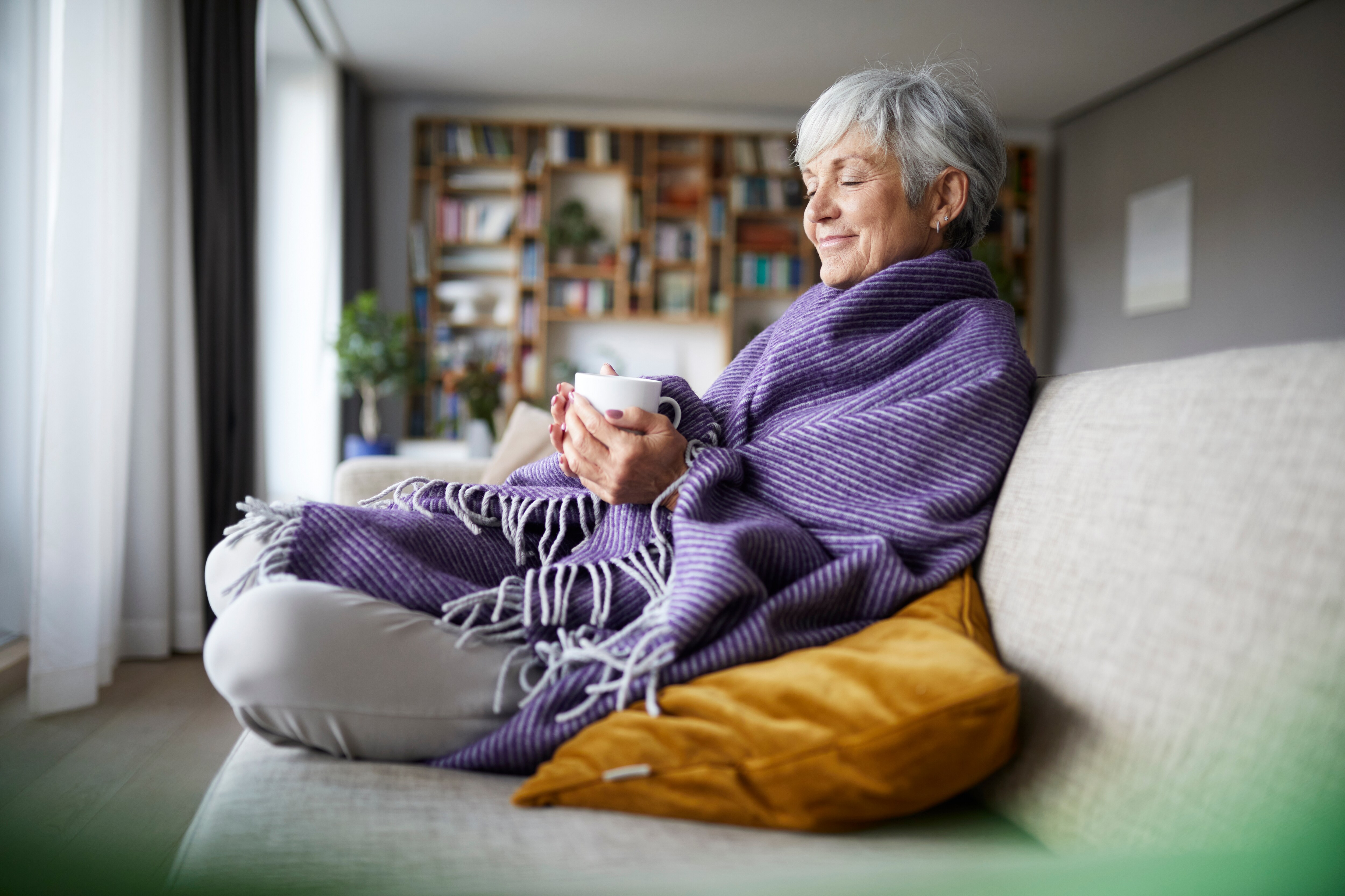 Ältere Frau sitzt auf einer Couch