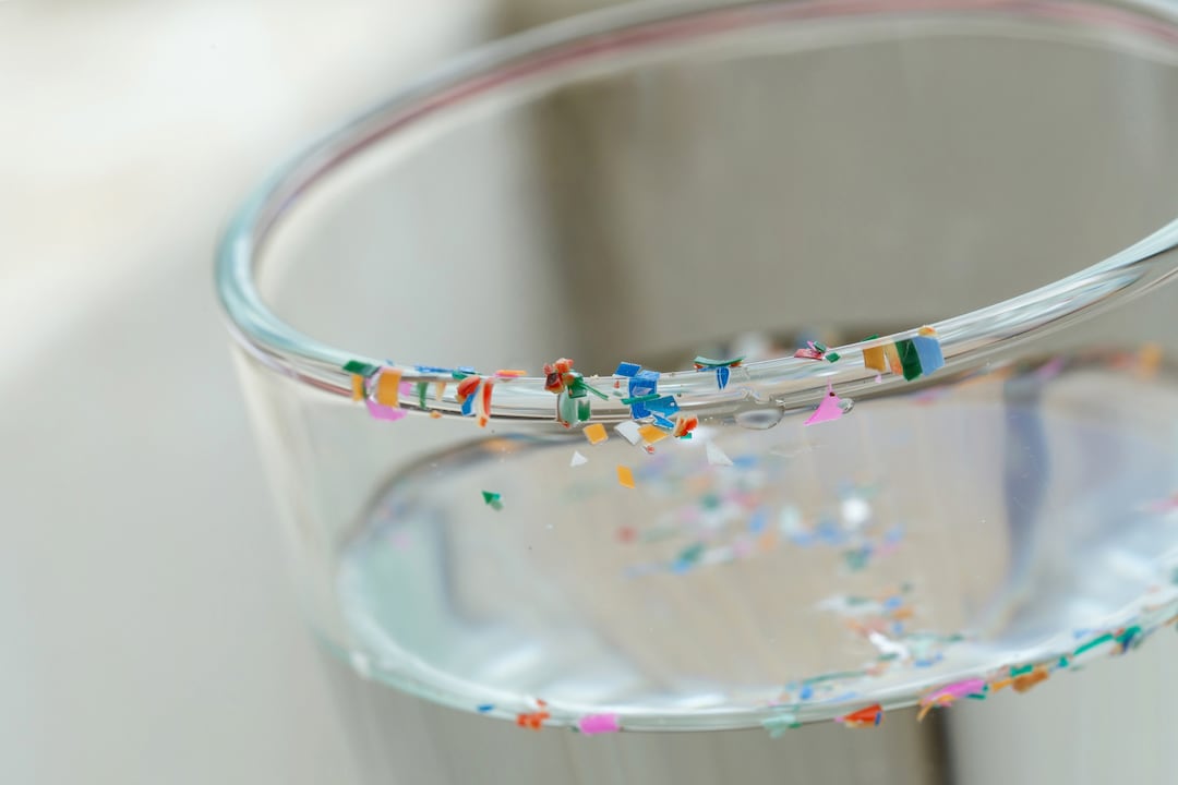 Microplasticdeeltjes op een waterglas