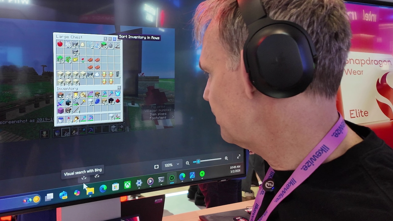 A person wears the Razer Project Motoko and looks at a screenshot from Minecraft.
