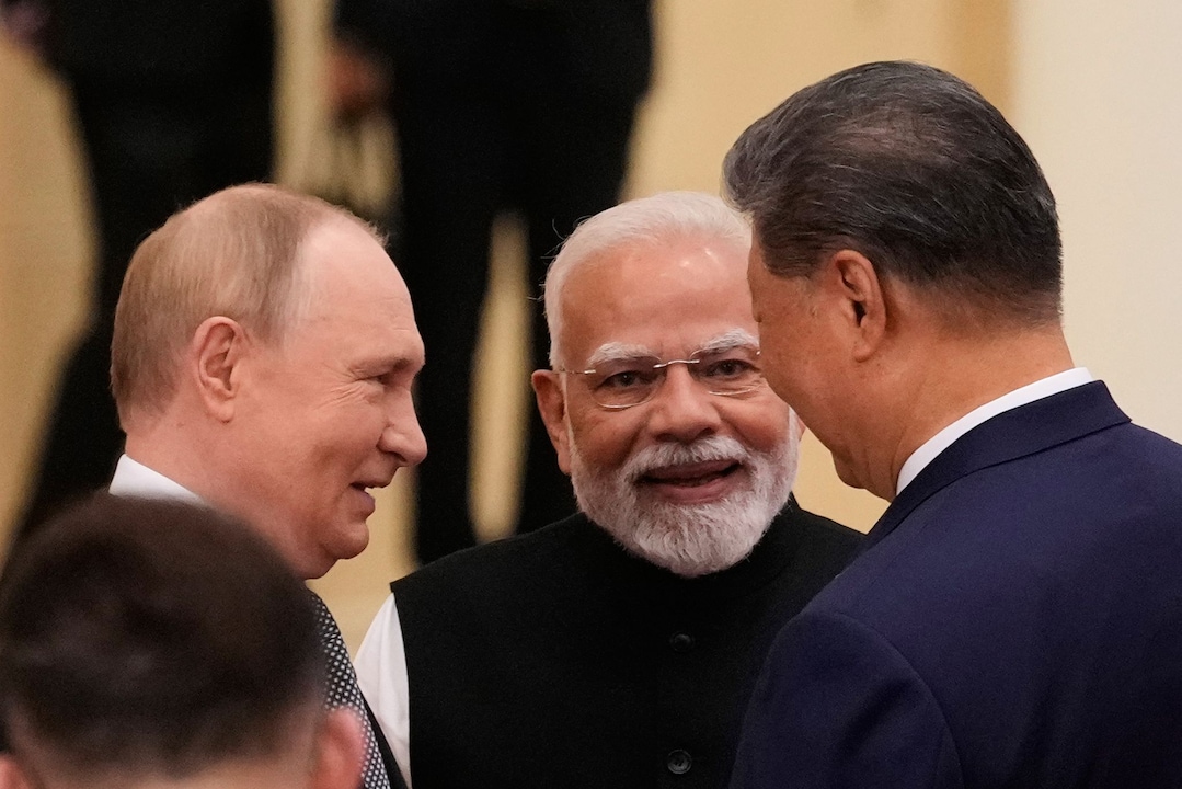 O presidente russo Vladimir Putin (da esq. para a dir.), o primeiro-ministro indiano Narendra Modi e o presidente chinês Xi Jinping conversam antes da cúpula da Organização de Cooperação de Xangai (OCX) no Centro de Convenções e Exposições de Meijiang.