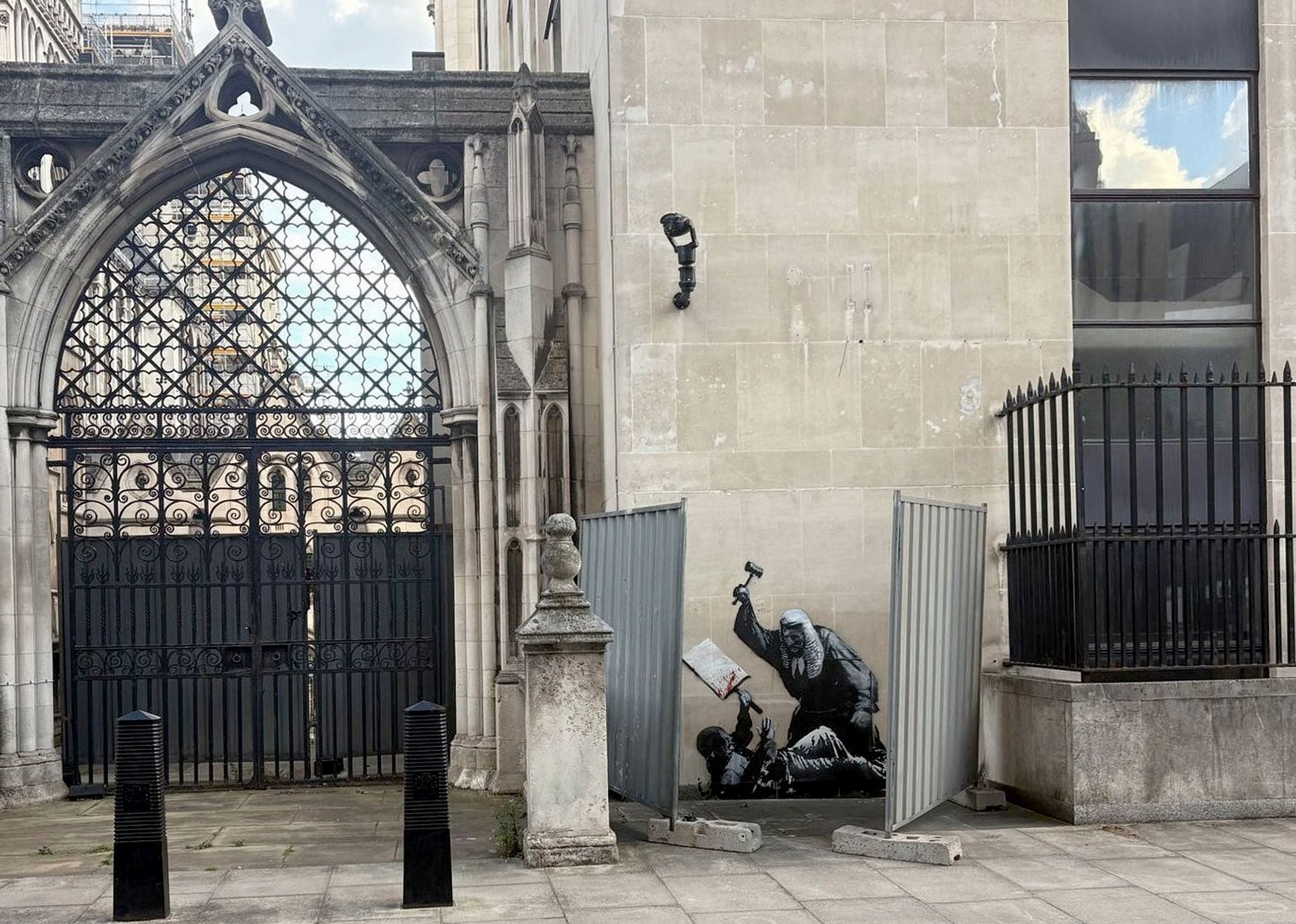 Ein neues Kunstwerk des Straßenkünstlers Banksy ist an der Fassade des Royal Courts of Justice zu sehen und zeigt einen Richter, der einen Demonstranten mit einem Hammer schlägt.