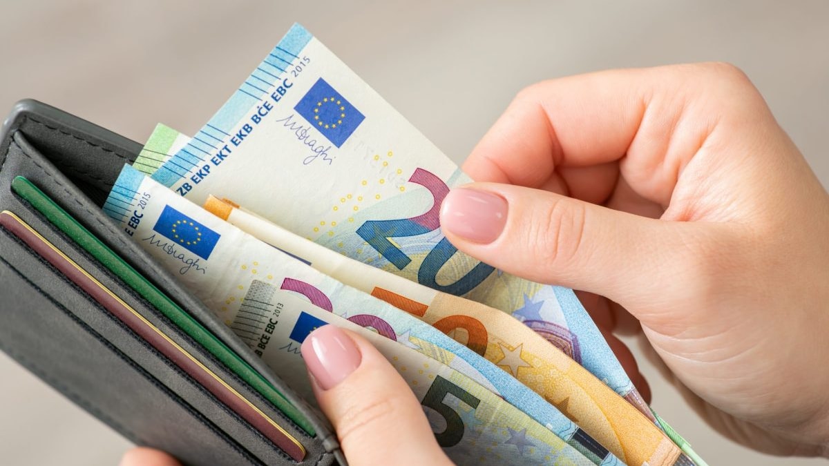 Person nimmt Geld aus einem Portemonnaie