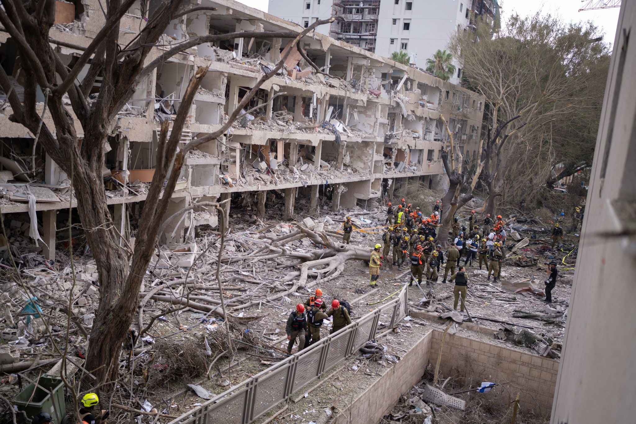 İran'ın İsrail'e yönelik saldırıları sonrası Tel Aviv'de yıkılan bir binanın etrafında kurtarma ekipleri toplandı.