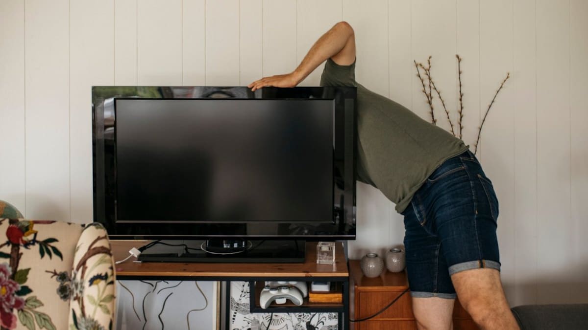 Mann versucht Fernseher zu reparieren.