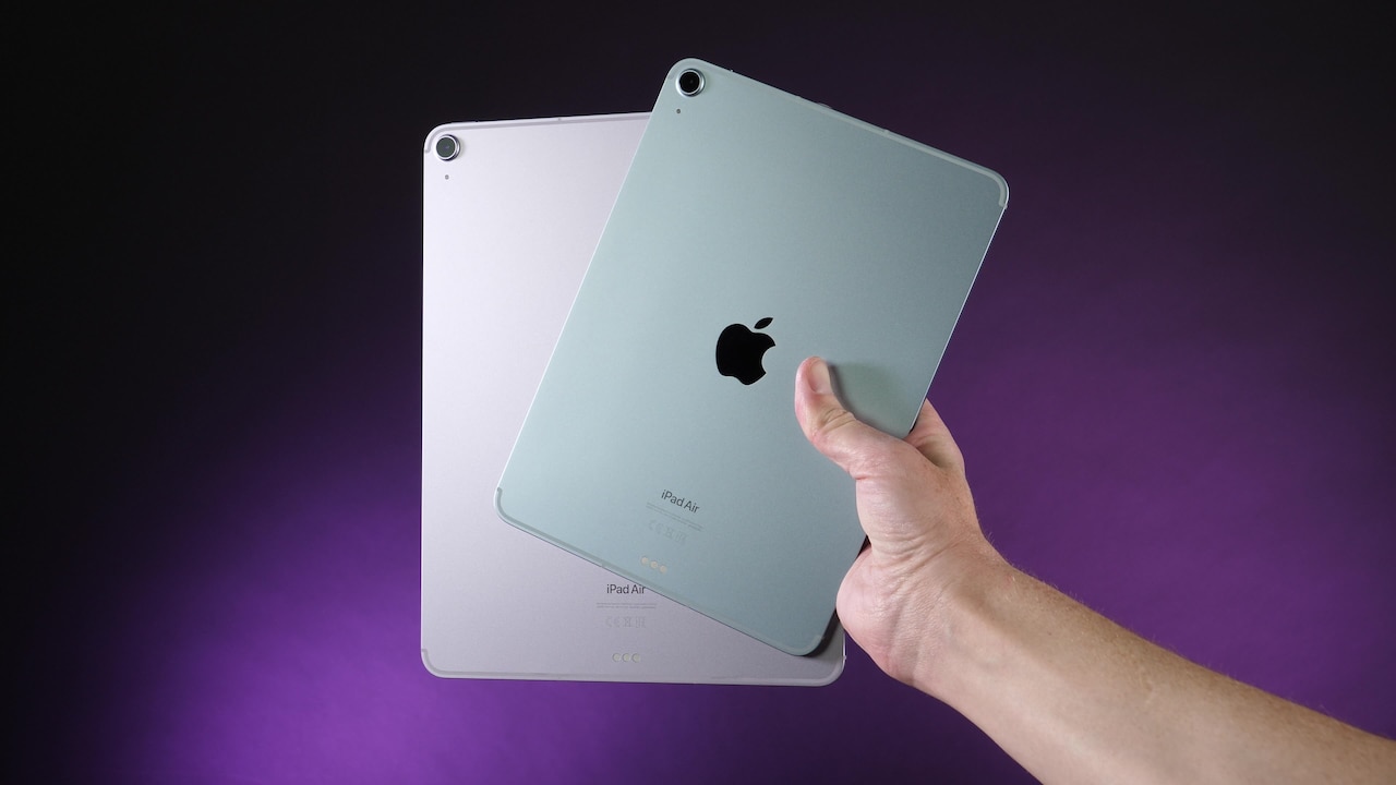 A person holds two variants of the iPad Air.