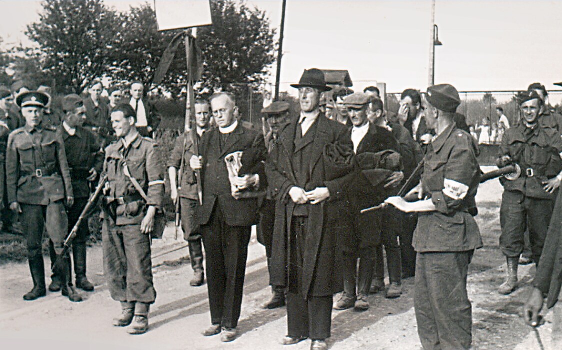 5. Juni 1945: Olešnice (Gießhübel) Revolutionsgardisten oder Soldaten der Tschechoslowakischen Armee nehmen Pfarrer Anton Rührich (mit Schild) fest. Sie ermorden ihn am 16. Juni in Peklo.