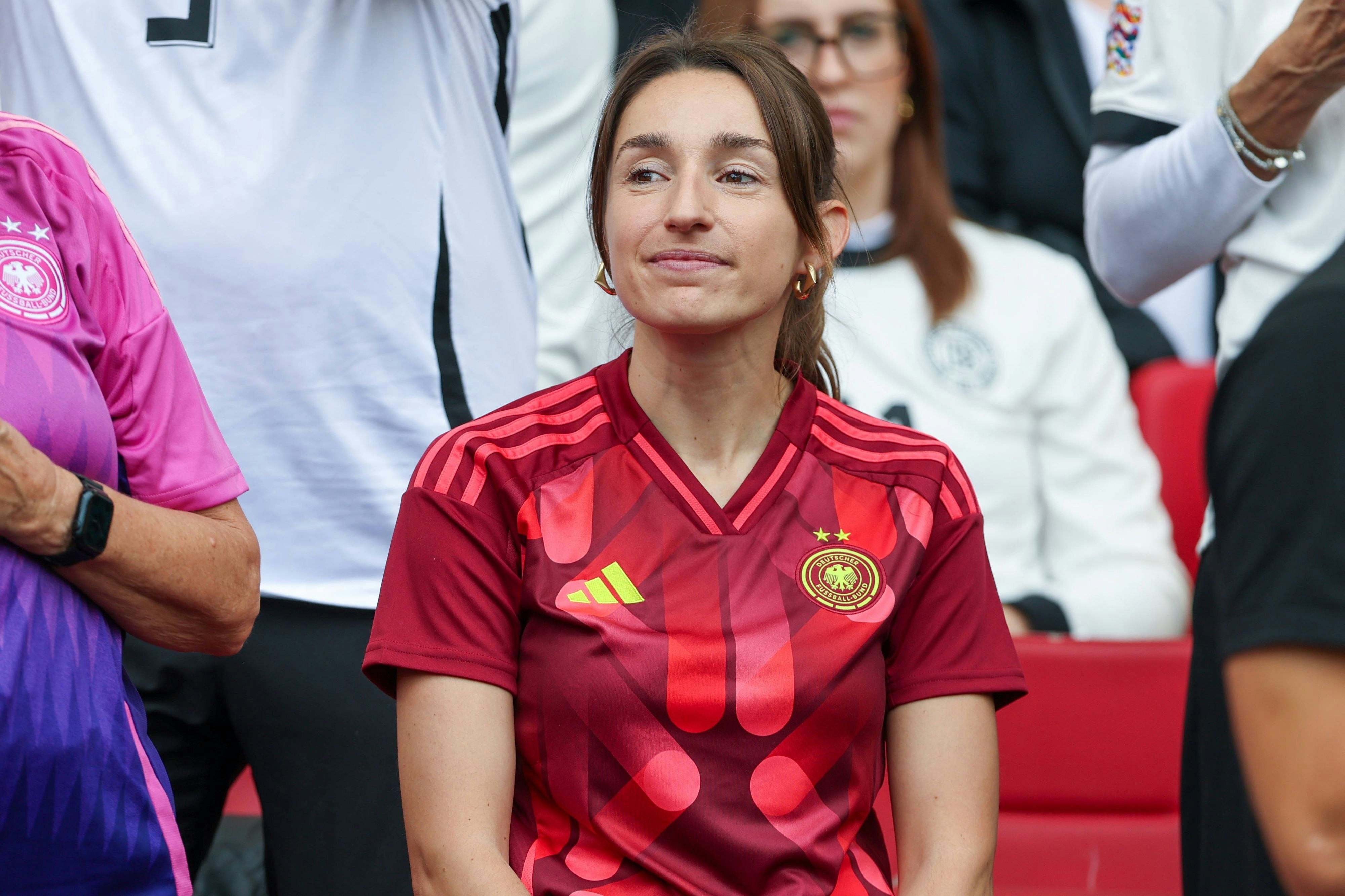Julian Nagelsmanns Freundin Lena Wurzenberger sitzt im roten DFB-Trikot auf der Tribüne.