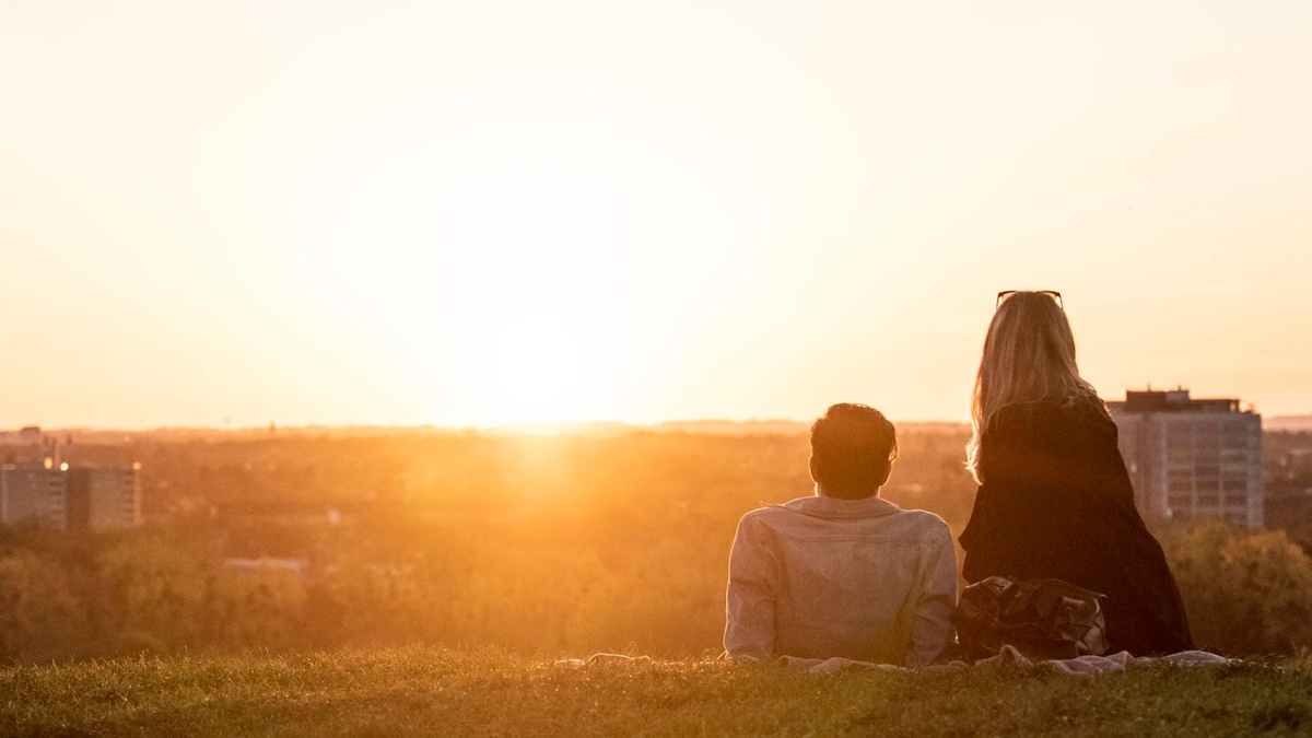 Münchner genießen die letzten Sonnenstrahlen des Tages im Olympiapark in München.