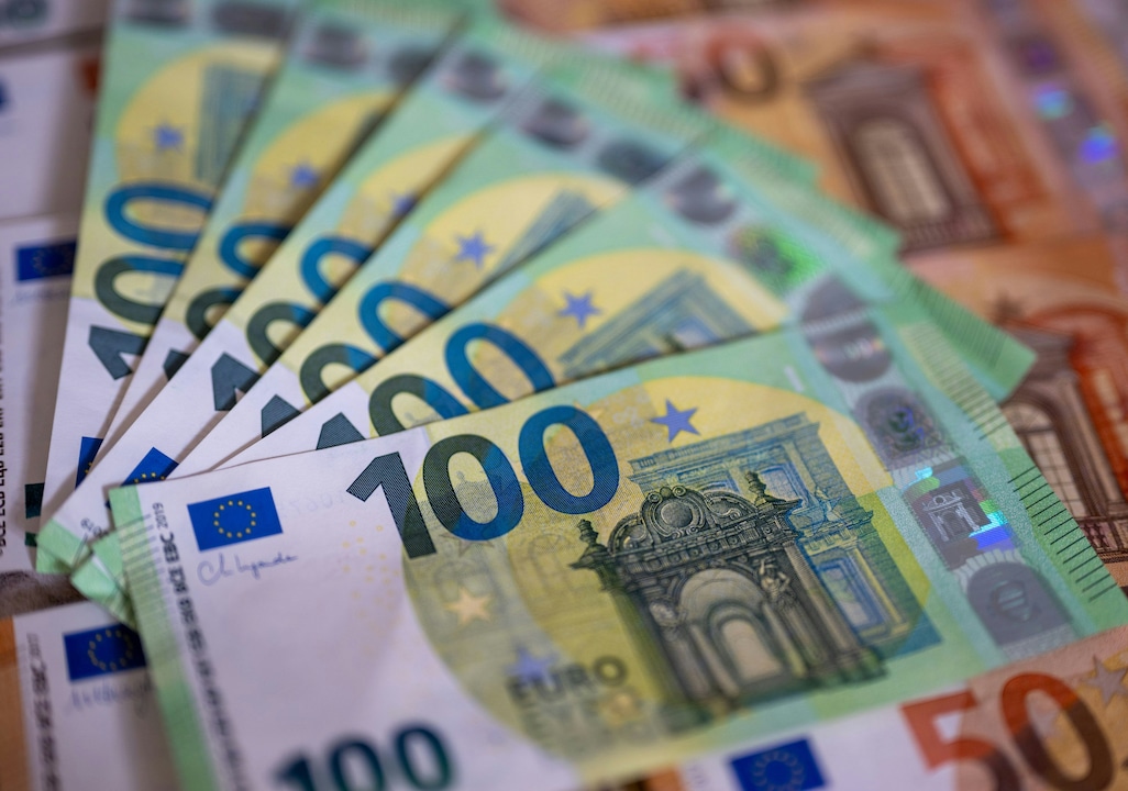 Banknotes with denominations of 100 and 50 euros lie on a table.